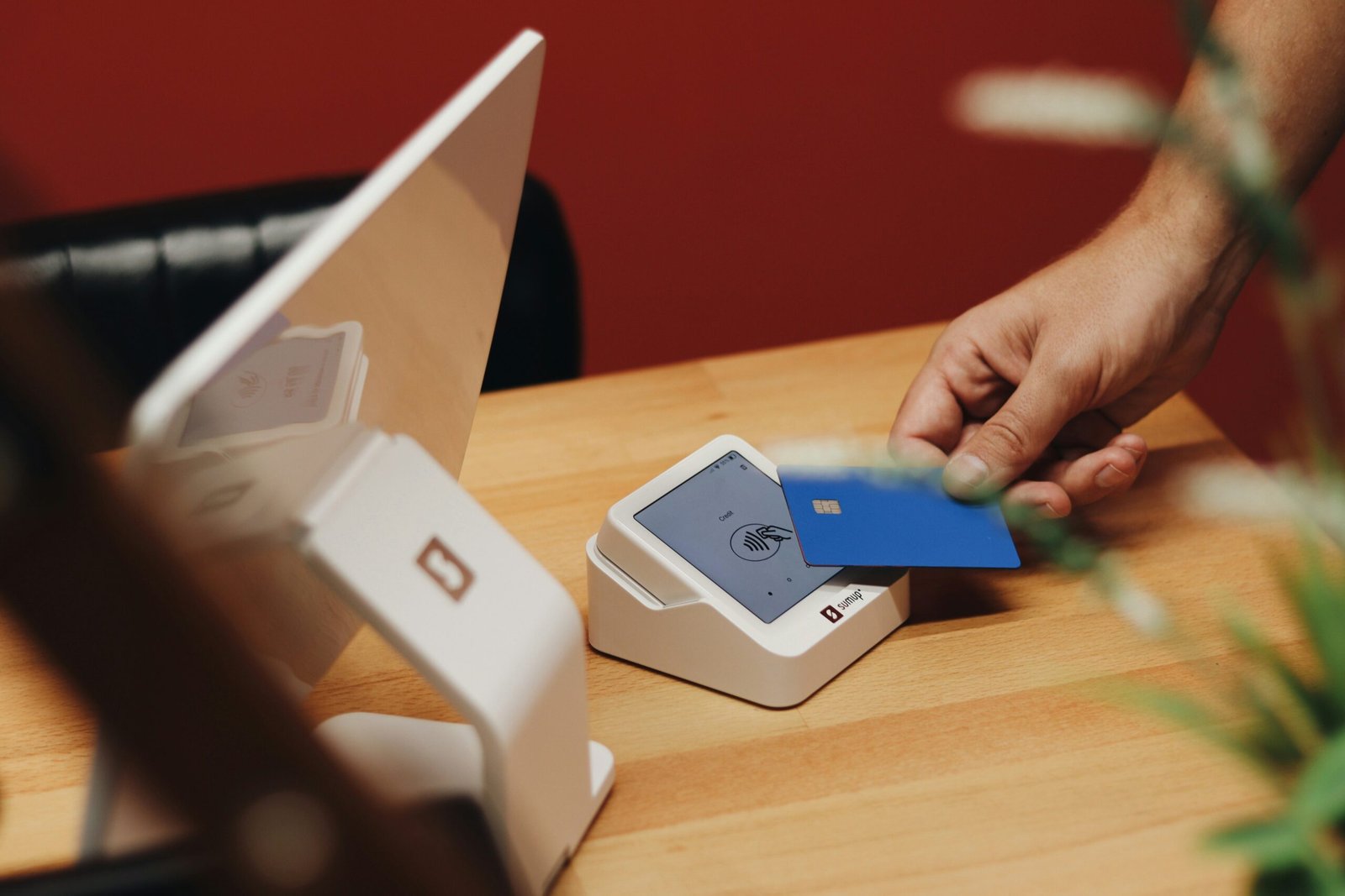 A person holding a credit card near a laptop